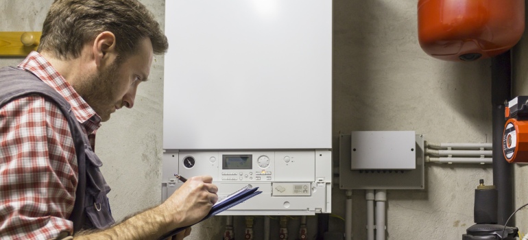 Gas-certified heating engineer who inspects a condensing boiler pipe leak 