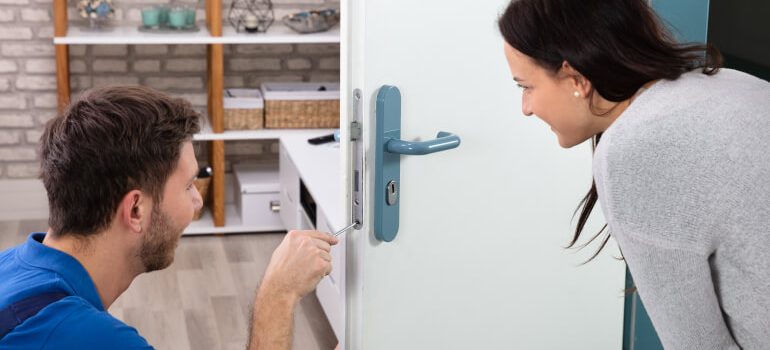 Locksmith fixing a door lock for a customer